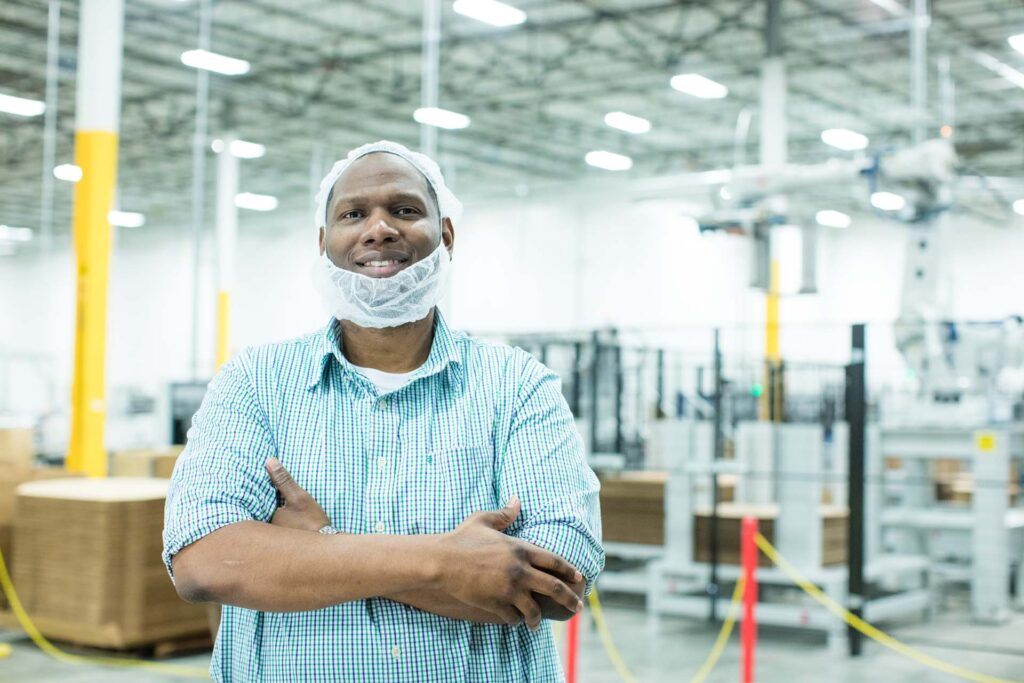 Worker Smiling and Content Inside a Facility